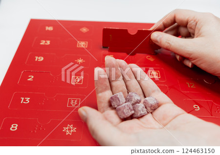 Red advent calendar for kids and adults with sweets 124463150