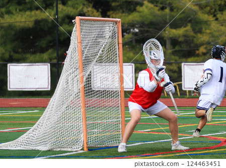 Goalkeeper Makes a Save During High School Lacrosse Match on the Field 124463451