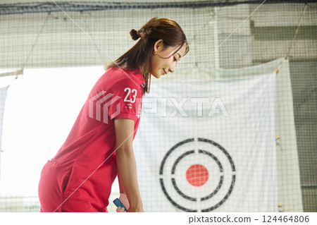 一名女子在室內高爾夫練習場練習 一名女子在室內高爾夫練習場練習 124464806