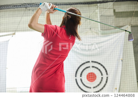 一名女子在室內高爾夫練習場練習 124464808