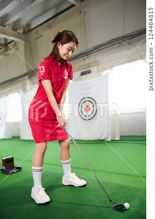 一名女子在室內高爾夫練習場練習 124464815