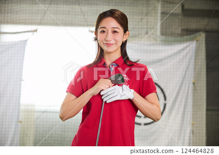一名女子在室內高爾夫練習場練習 124464828