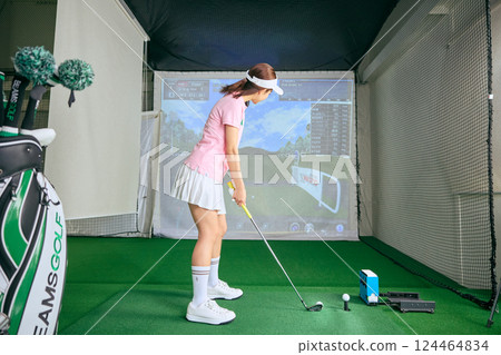 一名女子在室內高爾夫練習場練習 124464834