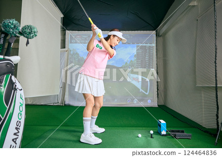一名女子在室內高爾夫練習場練習 124464836