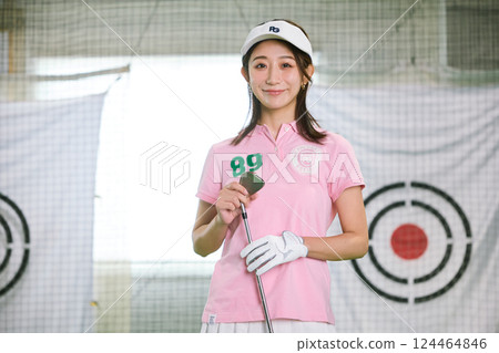 一名女子在室內高爾夫練習場練習 一名女子在室內高爾夫練習場練習 124464846