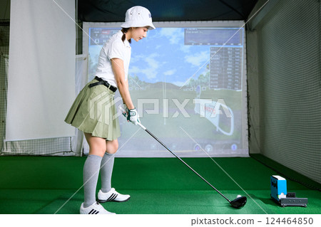 一名女子在室內高爾夫練習場練習 124464850