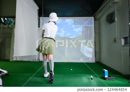 一名女子在室內高爾夫練習場練習 124464854