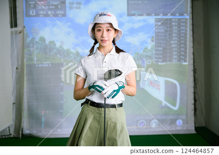 一名女子在室內高爾夫練習場練習 124464857