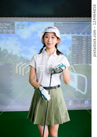 一名女子在室內高爾夫練習場練習 124464858