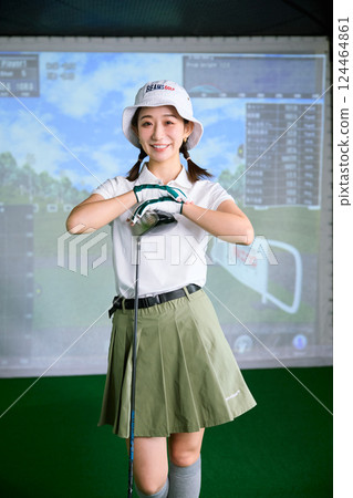 一名女子在室內高爾夫練習場練習 124464861