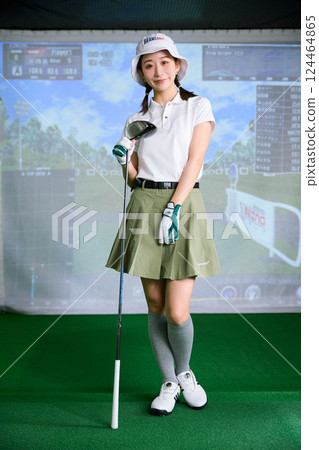 一名女子在室內高爾夫練習場練習 124464865