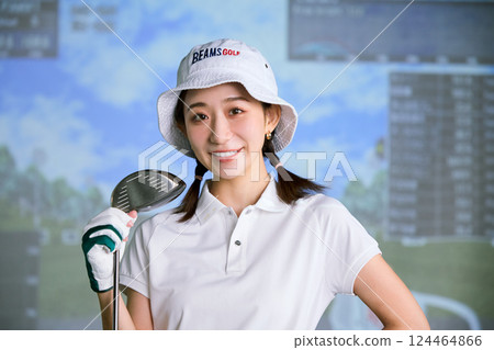 一名女子在室內高爾夫練習場練習 一名女子在室內高爾夫練習場練習 124464866