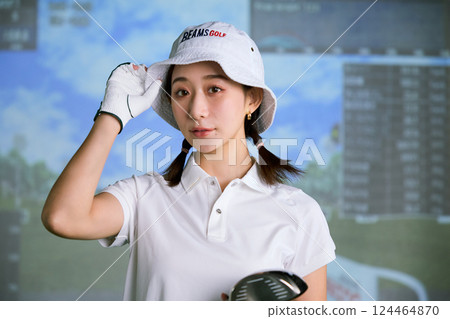 一名女子在室內高爾夫練習場練習 124464870