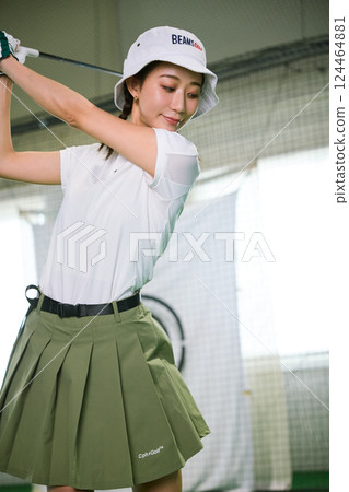 一名女子在室內高爾夫練習場練習 124464881