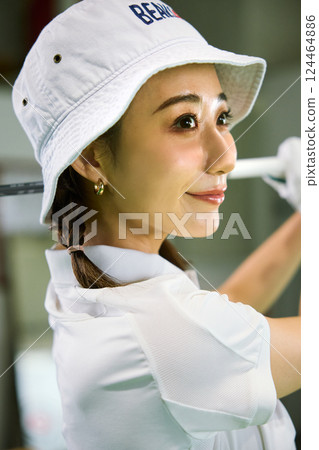 一名女子在室內高爾夫練習場練習 124464886