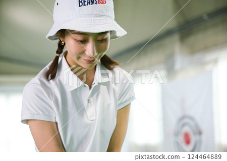 一名女子在室內高爾夫練習場練習 124464889