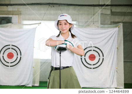 一名女子在室內高爾夫練習場練習 124464899