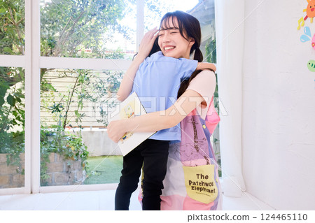 A nursery teacher hugging a child A nursery teacher hugging a child 124465110