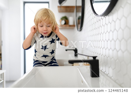 Boy spitting toothpaste and water after brushing his teeth. Morning routine for young boy before going to preschool. Boy spitting toothpaste and water after brushing his teeth. Morning routine for young boy before going to preschool. 124465148