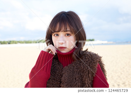 穿著毛皮背心在沙灘上行走的女人 124465729