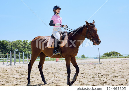 A woman practicing horse riding 124465805
