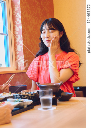 A woman dining at a restaurant 124465872