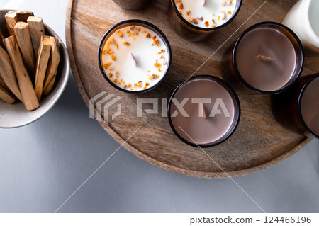 Aromatic scented candles with wooden wicks on round tray 124466196