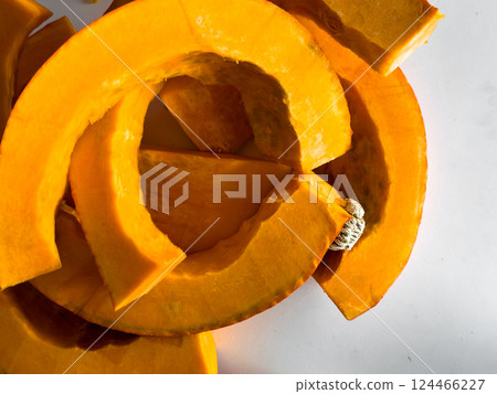 Fresh sliced pumpkin on white background with bright orange color and textured surface Fresh sliced pumpkin on white background with bright orange color and textured surface 124466227