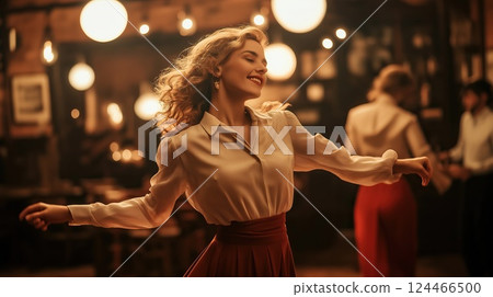A woman in a vintage white blouse and red skirt spins gracefully in a warmly lit setting 124466500
