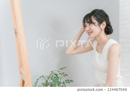 Japanese woman with a smile checking her bangs and hair set 124467048