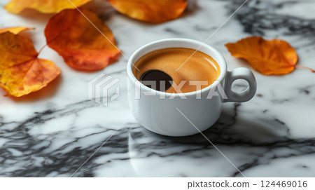 A minimalist composition of espresso and autumn leaves on a marble table 124469016