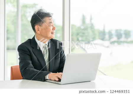 Senior Asian male businessman in a suit sitting at a desk 124469351