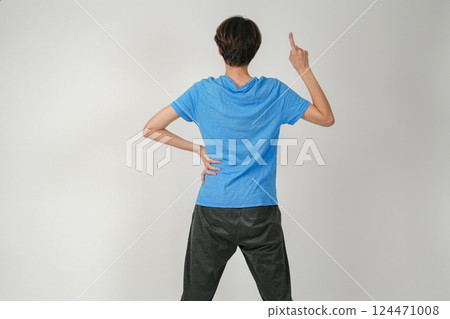 A man facing backwards and pointing up 124471008