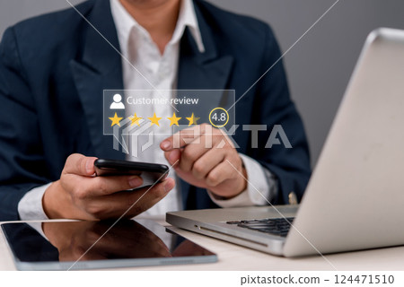 A businessman using a smartphone to check customer reviews and ratings. Online feedback, reputation management, and digital marketing concept for business growth. 124471510
