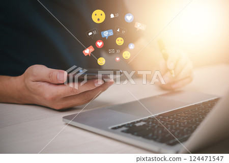 Hands using a smartphone with floating social media icons, representing digital interaction and online engagement. networking, communication, and real-time messaging in the modern world. Hands using a smartphone with floating social media icons, representing digital interaction and online engagement. networking, communication, and real-time messaging in the modern world. 124471547