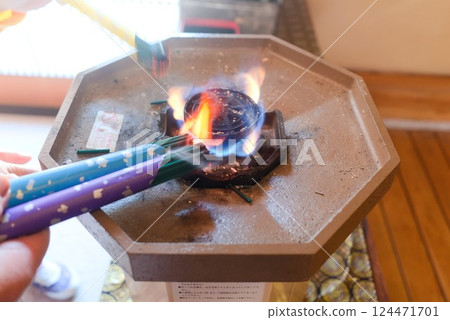 A quiet moment as incense sticks are lit in an incense offering tool A quiet moment as incense sticks are lit in an incense offering tool 124471701