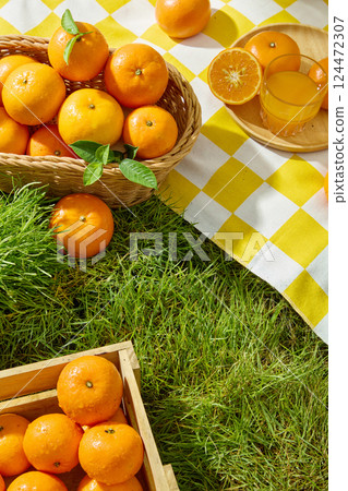 Overhead view of a light brown rectangular wooden crate filled with fresh ripe oranges. The inside surface of the oranges are juicy orange segments with white lines dividing them. Nature concept 124472307