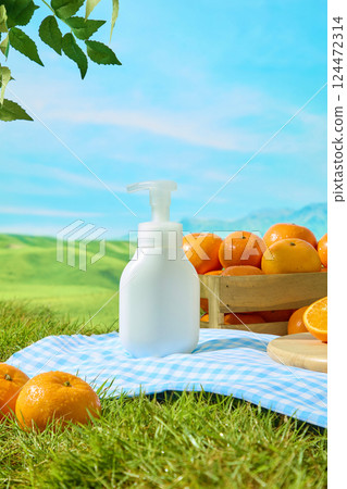 Frontal of unlabeled cosmetic bottles on a blue checkered carpet. Fresh oranges with smooth skins and morning dew drops. Decorative branches and leaves above, sunlight shining everywhere Frontal of unlabeled cosmetic bottles on a blue checkered carpet. Fresh oranges with smooth skins and morning dew drops. Decorative branches and leaves above, sunlight shining everywhere 124472314
