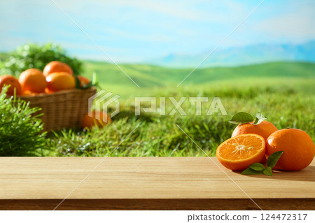 Fresh oranges cut in half to reveal juicy flesh with tiny orange seeds placed on a light brown wooden stick. Hand-woven rattan basket filled with ripe oranges, displayed on green grass. Fresh oranges cut in half to reveal juicy flesh with tiny orange seeds placed on a light brown wooden stick. Hand-woven rattan basket filled with ripe oranges, displayed on green grass. 124472317