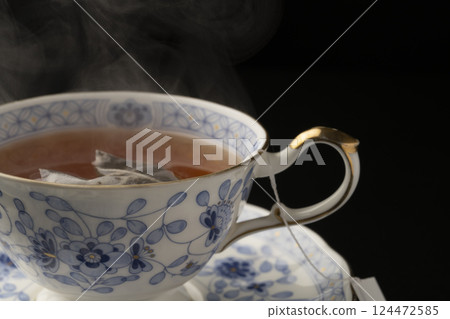 Pouring tea into a cup using a tea bag Pouring tea into a cup using a tea bag 124472585
