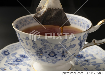 Pouring tea into a cup using a tea bag Pouring tea into a cup using a tea bag 124472589