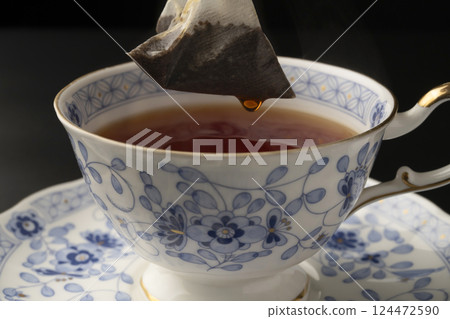 Pouring tea into a cup using a tea bag Pouring tea into a cup using a tea bag 124472590