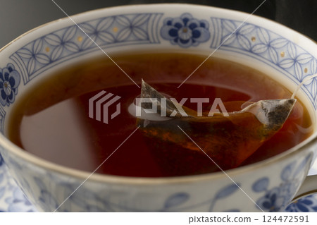 Pouring tea into a cup using a tea bag 124472591