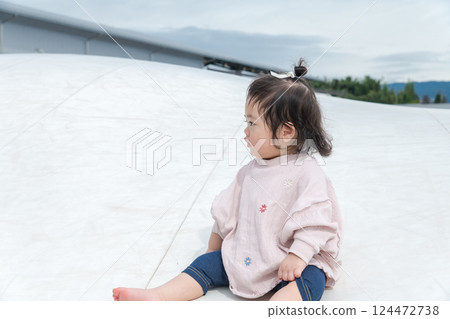 [Infants sitting on giant playground equipment] 124472738