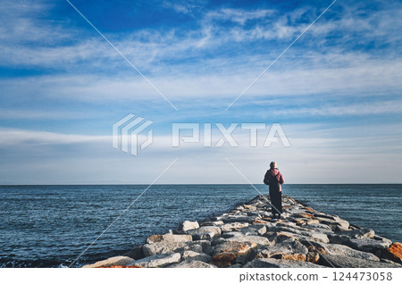 Back view of a woman looking at the sea 124473058