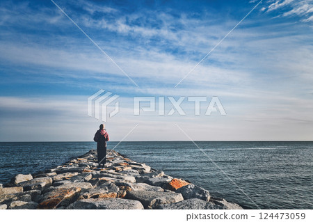 Back view of a woman looking at the sea Back view of a woman looking at the sea 124473059