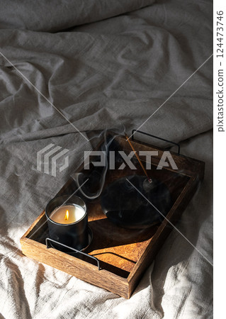 Incandescent Candle and Incense Burning Creating Cozy Mood. Home Decor Idea for Calm Autumn Day. Incandescent Candle and Incense Burning Creating Cozy Mood. Home Decor Idea for Calm Autumn Day. 124473746