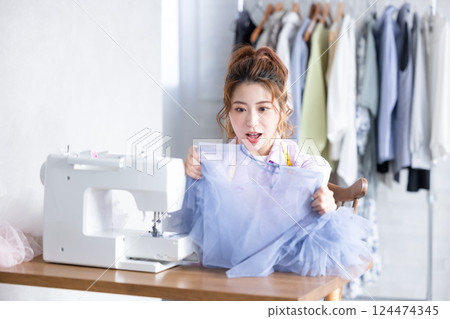 A woman sewing with a sewing machine 124474345