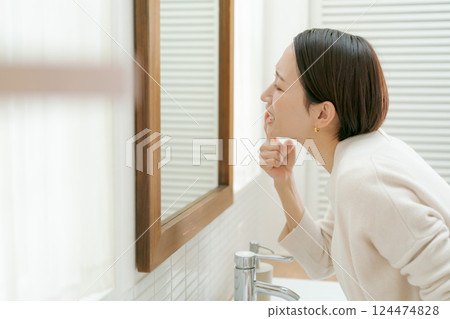 中年婦女在浴室裡看著她的嘴 124474828