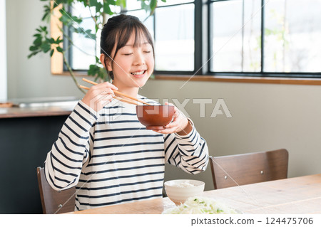 在餐桌上吃飯的小學和國中女生 124475706